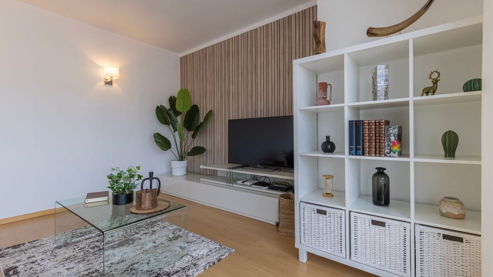 Relax in this chic living space, where a plush rug and ample seating invite you to unwind after a day of exploration, all while enjoying your favorite shows on the large flat-screen TV. The unique textured wall and contemporary decor add a touch of sophis