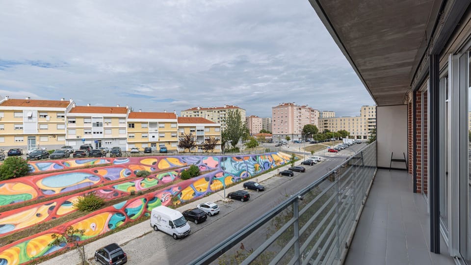 Enjoy a vibrant city view from your private balcony, perfect for morning coffee or evening relaxation while overlooking the unique urban art below. This inviting outdoor space connects you directly to the lively local atmosphere. #CityView #PrivateBalcony
