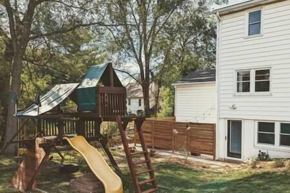 The playset has a tire swing, monkey bars, climbing wall, multiple swings, fort & slide