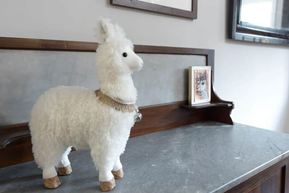Gorgeous vintage mahogany server features a marble top graced by a cute alpaca.