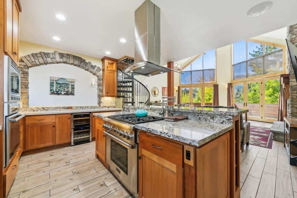 Spacious South Lake Tahoe kitchen stocked with cookware, bakeware, dinnerware, serving dishes and utensils, plus a gas range, two ovens and generous counter space for preparing meals for larger groups.