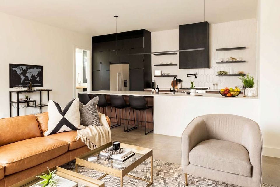 Leather sofa, armchairs, and a kitchen island in view, this house is built for a group getaway where everyone actually hangs out together