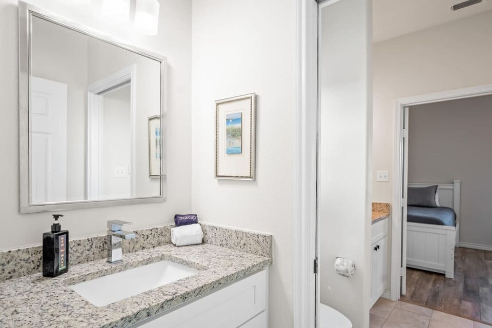 `Private Ensuite Bath – Granite Vanity & Light Coastal Decor`