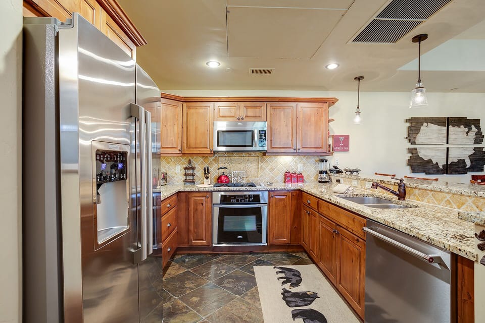 Your gourmet kitchen awaits with granite counters, stainless appliances, and warm wood cabinets—perfect for creating memorable meals together.