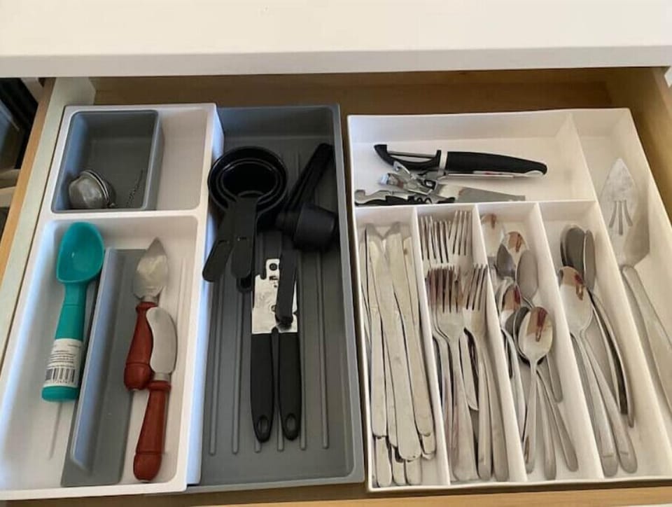 Plenty of utensils, can opener, measuring cups, tea diffuser, peeler