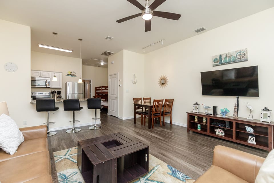 Relax in your spacious living area with leather seating, entertainment center, and open kitchen - perfect for memorable vacation moments together.