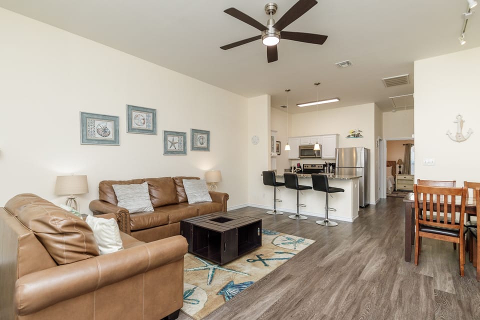 Sink into plush leather sofas while the ceiling fan keeps you cool in this open-concept space that flows seamlessly to your modern kitchen.