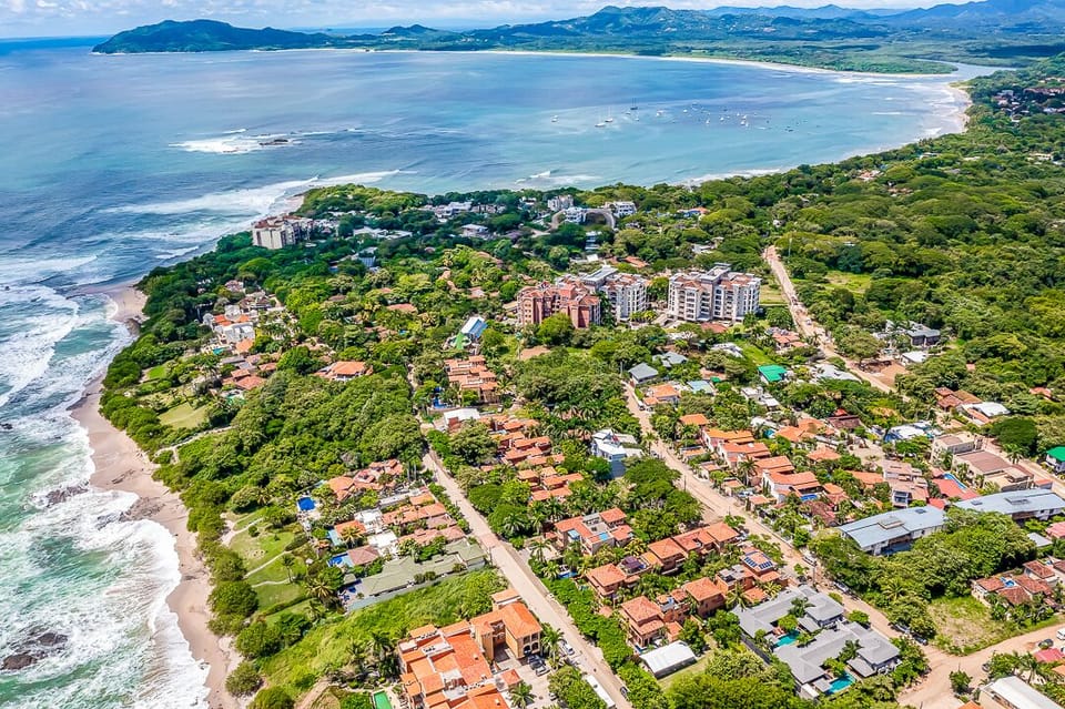 Aerial view of Langosta Beach and its surroundings in Tamarindo, showcasing Langosta Village, nearby Tamarindo Beach, and downtown in the background. Perfectly located for easy beach access, local dining, and a luxury Costa Rica vacation.