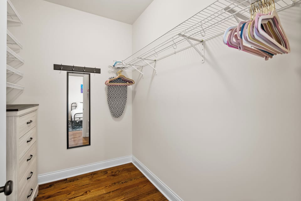 Huge walk-in closet with dresser, mirror, iron, and ample space