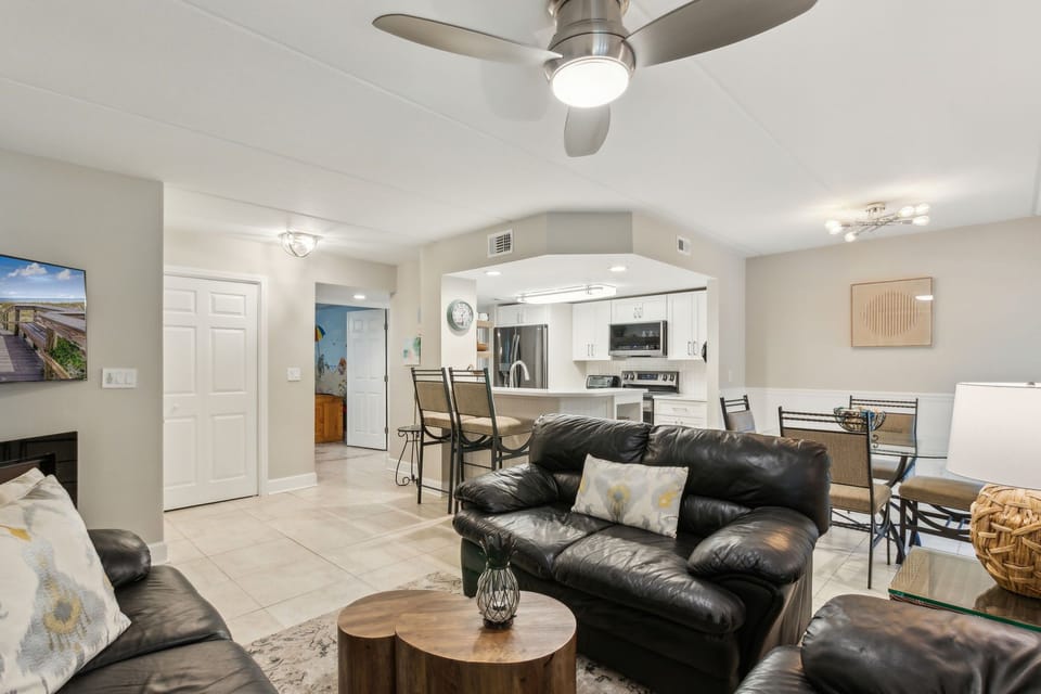 Spacious Living Area with Comfortable Seating Centered Around a Flat Screen TV and Electric Fireplace