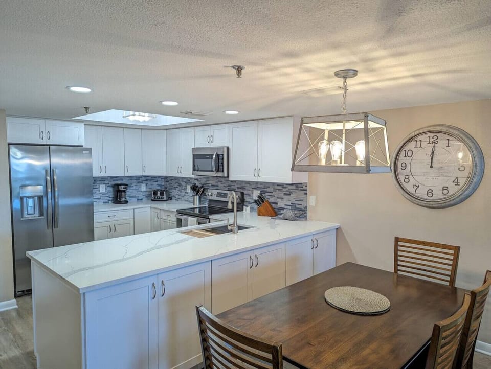 Bright kitchen w/ generous island seating, stainless appliances, & an open flow to dining.