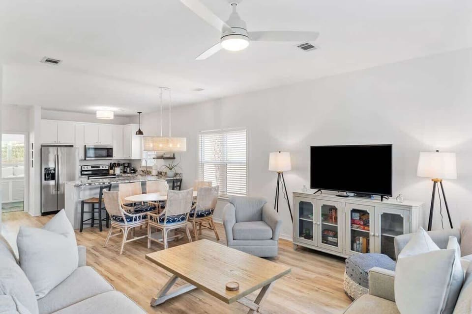 - Bright, open & inviting living room is ready for movie nights, meals, & memories - Seamless flow to the kitchen & dining area means you're always part of the fun - With comfy seating, a large smart TV, & stylish touches, it’s your favorite hangout
