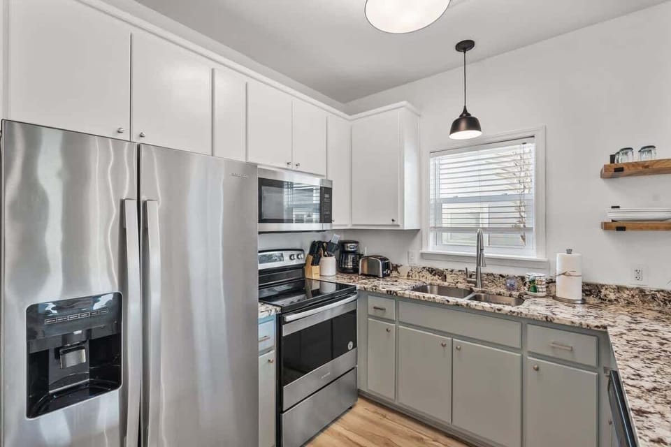 - Whip up meals in this sleek kitchen featuring granite countertops & stainless appliances - Stocked with essentials & extras like a coffee station & toaster, just bring your appetite - Clean, stylish, & practical, it’s the perfect spot to fuel your