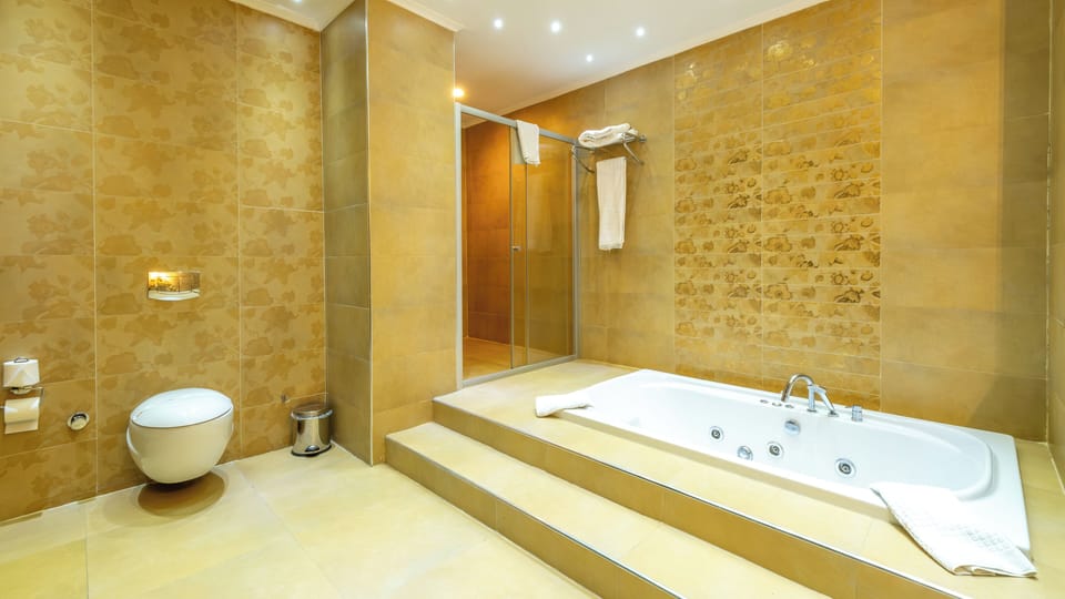 King Suite | Bathroom | Deep soaking tub, hydromassage showerhead, free toiletries, hair dryer