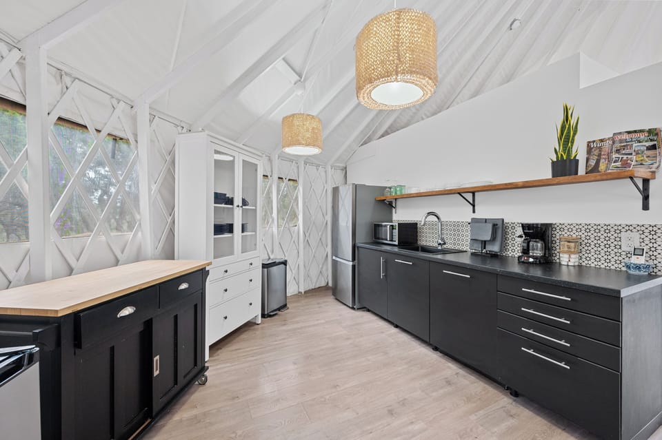Kitchen with coffee maker, refrigerator with a small freezer and a microwave.