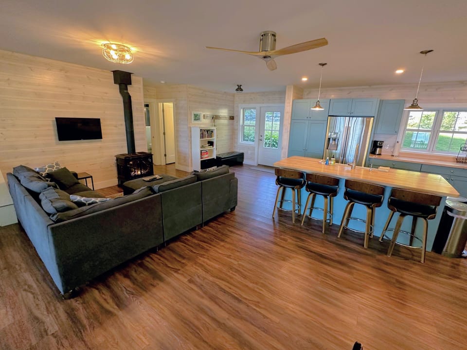 Open concept kitchen, dining and living space on the main level with Fireplace, barstool seating, TV and games.
