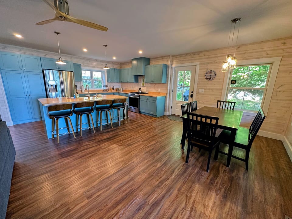 Open concept kitchen, dining and living space on the main level with Fireplace, barstool seating, TV and games.