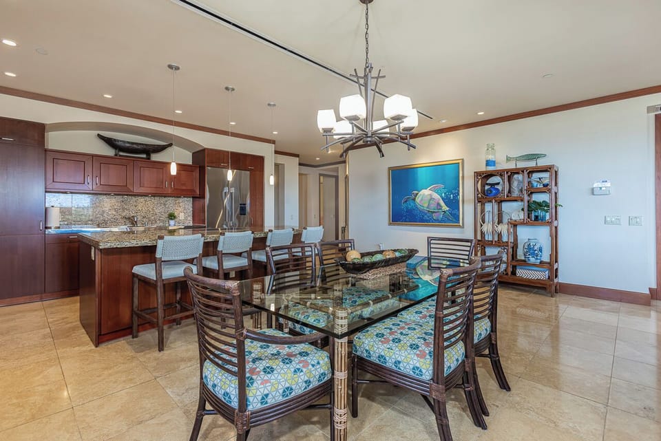 Gather for meals or casual conversations in this open-plan kitchen and dining space designed with coastal flair. The island seating and full dining table invite you to linger over breakfast or plan the day's adventures.