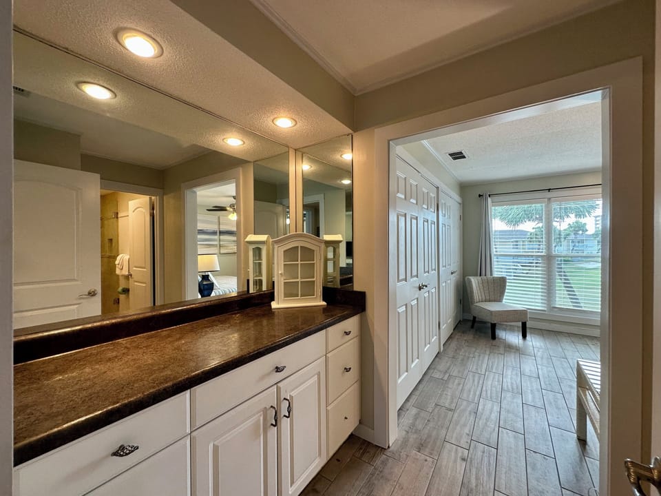 Pamper yourself in this elegant bathroom featuring rich granite counters and warm vanity lighting that creates the perfect ambiance for your morning routine.