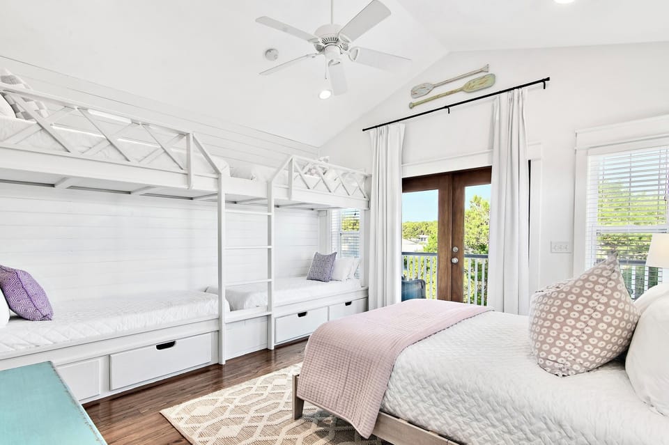 The 3rd floor bunk room: four twin XL bunks, a queen bed, and a dedicated wet bar with mini fridge. Comfortable for adults...or the kids get their own floor — everyone wins!