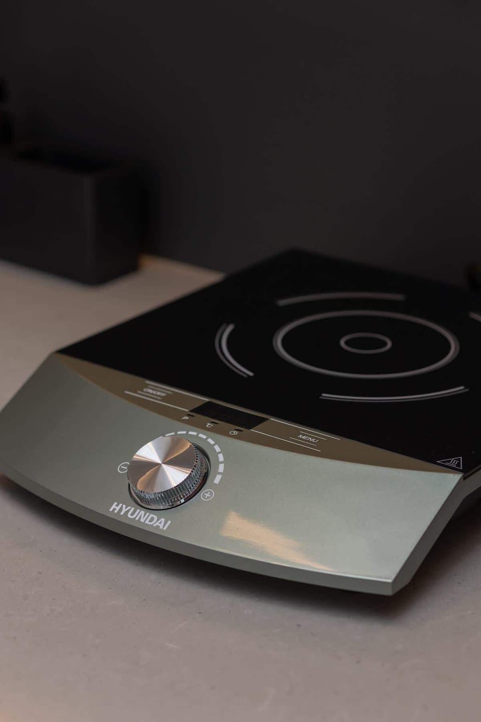 A close-up of a sleek black induction stove, emphasizing modern and efficient kitchen features.






