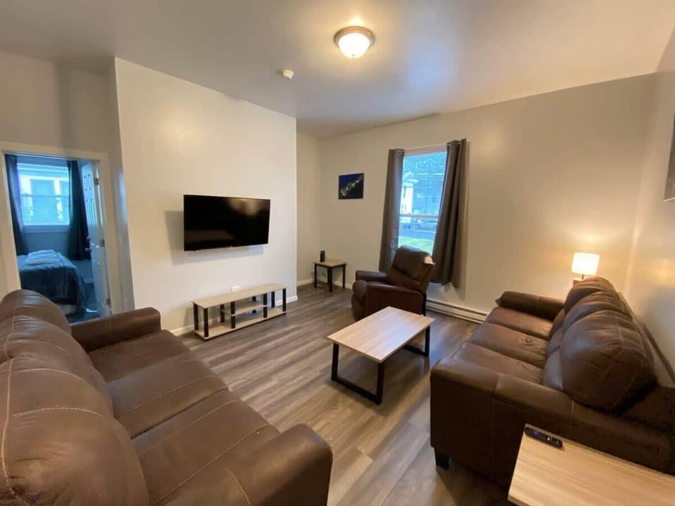 Enjoy a comfy living room with plush couches, a recliner, a flat-screen TV, and a coffee table. Watch 145+ channels on DirecTV for non-stop entertainment.