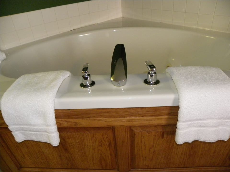 Suite, 1 King Bed, Jetted Tub | Desk, laptop workspace, blackout drapes, iron/ironing board