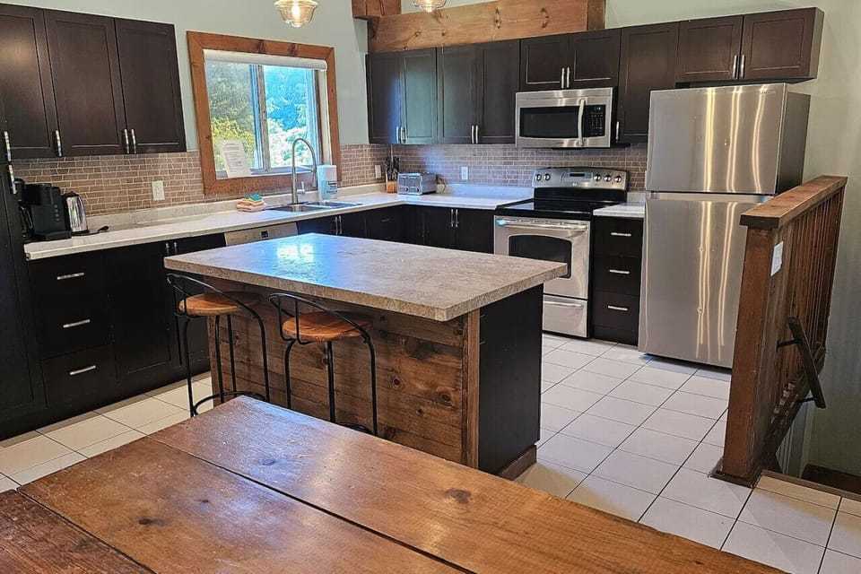 Overlooking the solid-wood dining table into the kitchen with island
