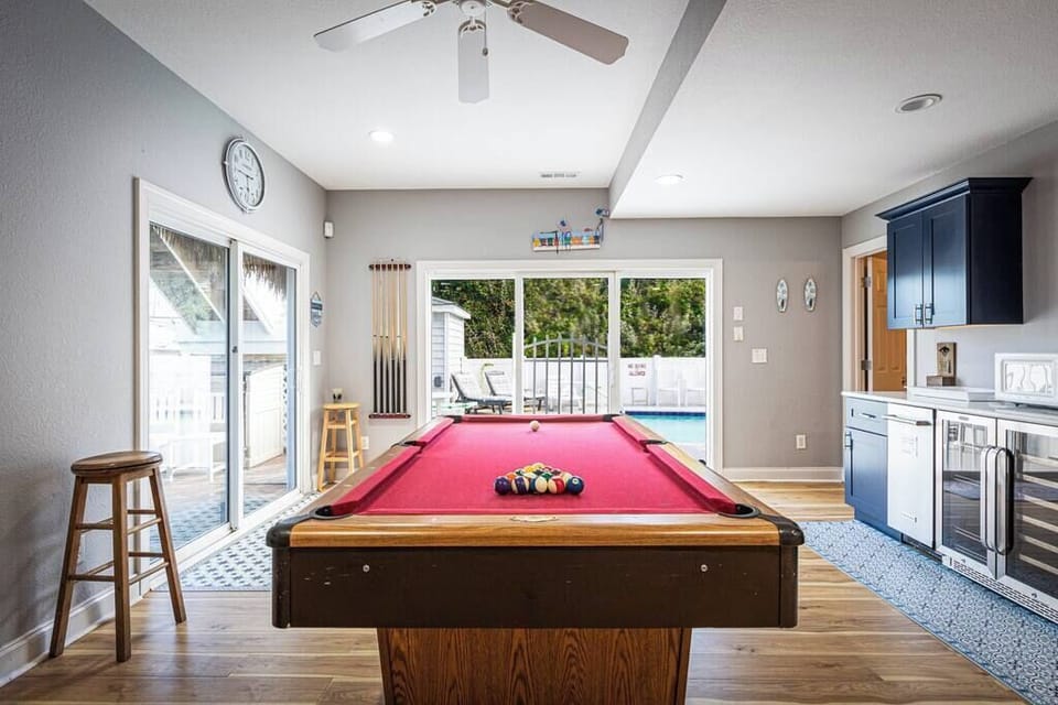 Lower Level: Game Room with pool table, wet bar area, and sliding doors leading directly to the pool for easy indoor-outdoor fun