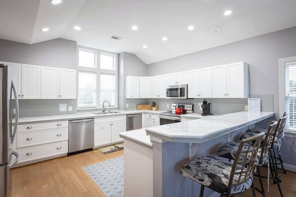 Top Level: Fully Stocked Kitchen with refrigerator, oven, microwave, dishwasher, coffee maker, and bar counter seating