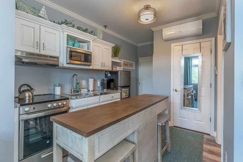 Fully Stocked Kitchen  w/ Breakfast Bar, Refrigerator, Microwave, Oven, Stove, Dishwasher, Coffee Maker, Cooking Utensils and Light Blue Accent Walls