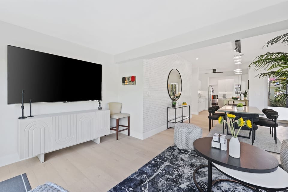 The living room keeps everyone connected with a large TV, comfortable seating, and an open flow to dining and kitchen spaces.