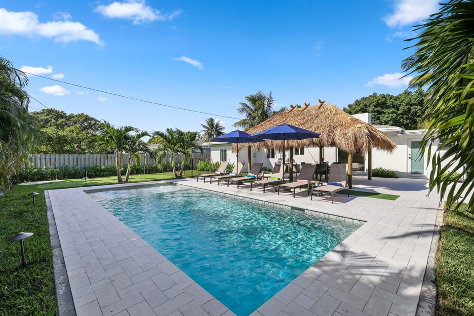 Spend sunny days by your private heated pool with loungers, umbrellas, a Tiki hut, and putting green all in one inviting backyard.