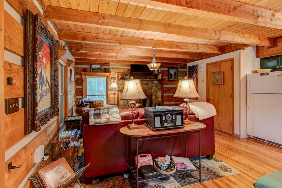 Settle into the cozy living room at Casa Haven, where warm wood walls and a stone fireplace set the perfect mountain mood.