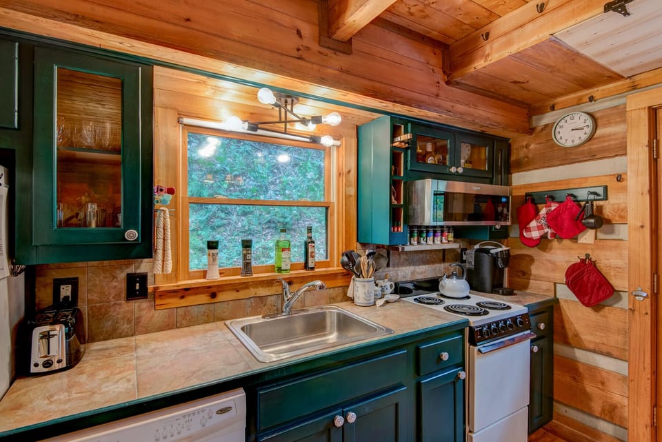 Cozy log cabin charm meets full kitchen convenience at Casa Haven, with a wooded view right from the sink.