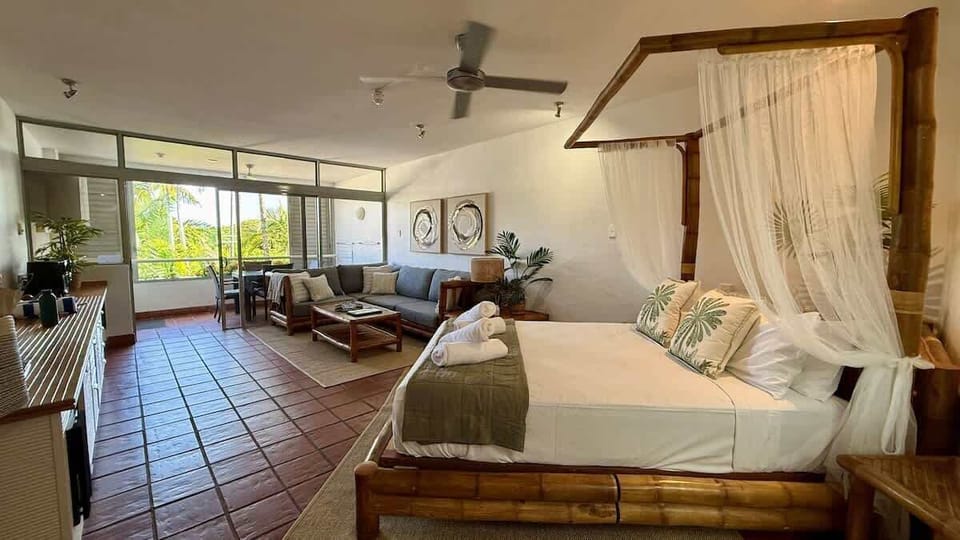 Featuring a stunning queen-size bed, handcrafted from solid bamboo, radiating a natural, tropical charm.  The design is both rustic and elegant, blending seamlessly into a relaxed, modern bohemian setting.