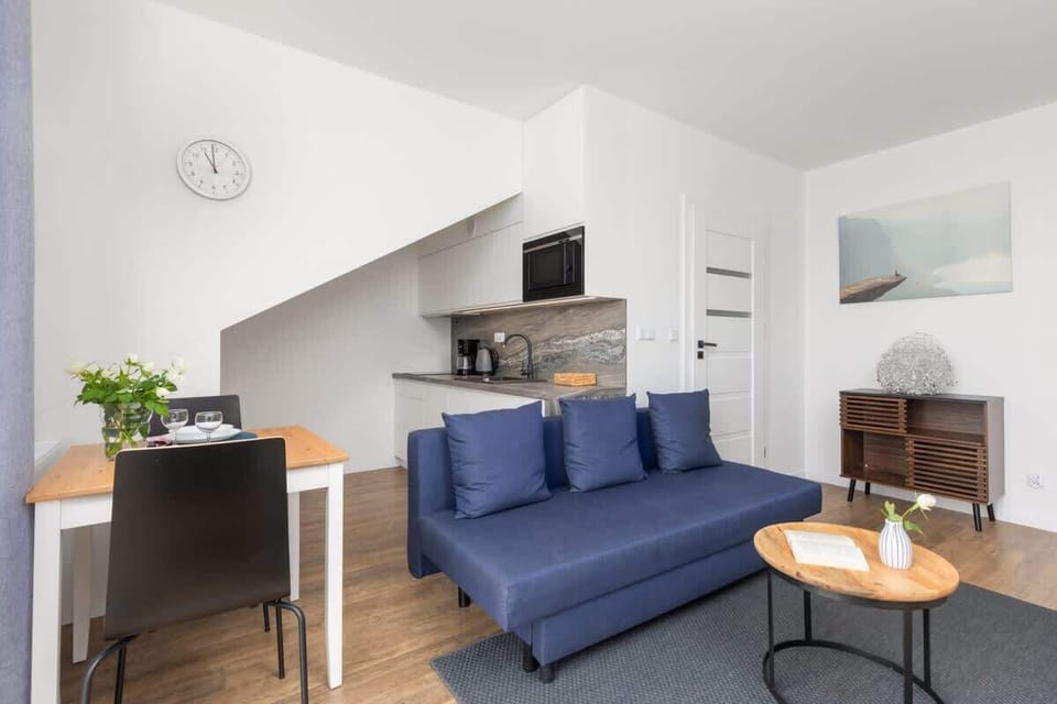A spacious open-plan living and dining area with modern furniture, light walls, and a welcoming atmosphere.
