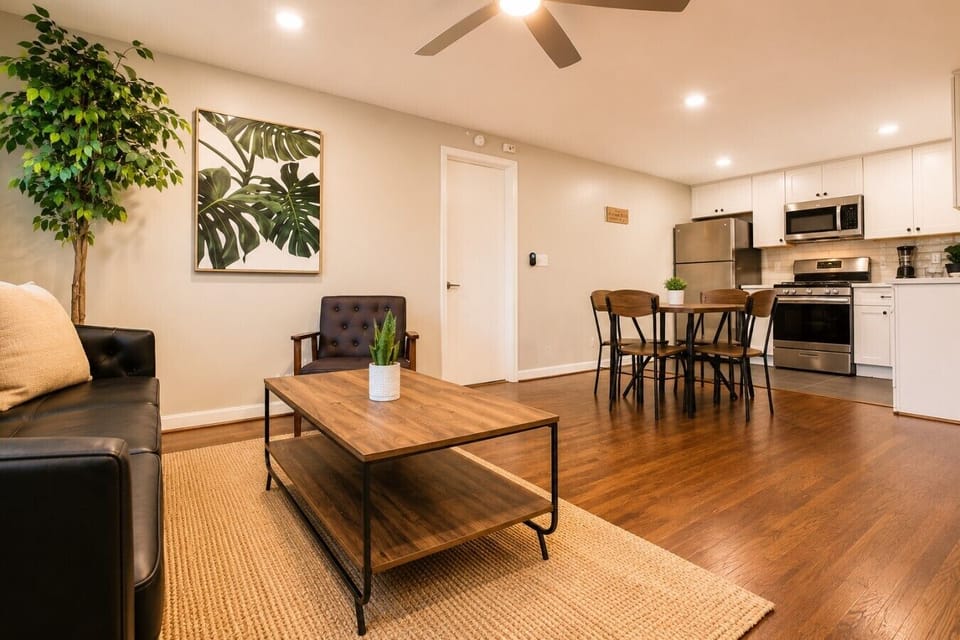 Stylish lounge corner with comfy seating, modern art, and sunlit windows.