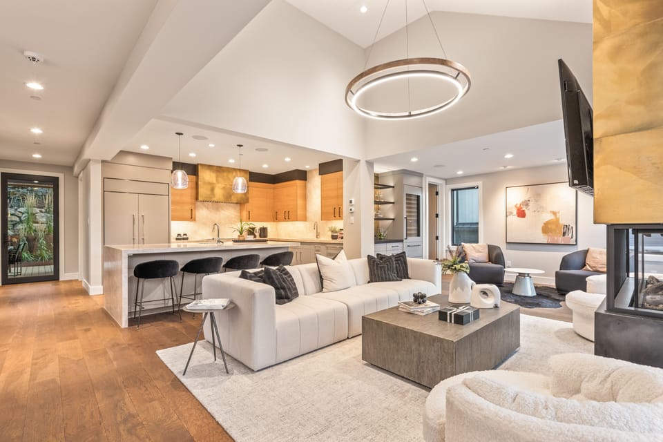 Unwind in the bright, open-concept living area featuring a vaulted ceiling, large sectional, and kitchen island seating.