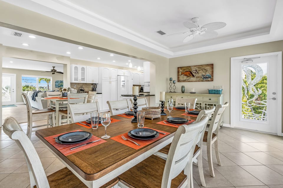 Dining area is bathed in natural light. The rear entrance offers balcony access