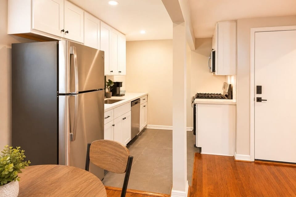 Bright kitchen with stainless steel refrigerator, dishwasher, and plenty of counter space.