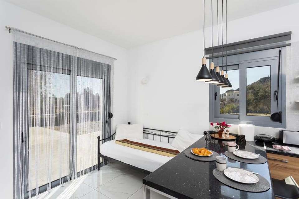 Open-plan living room with sofa, dining area, kitchen, A/C, WiFi internet, and satellite TV
