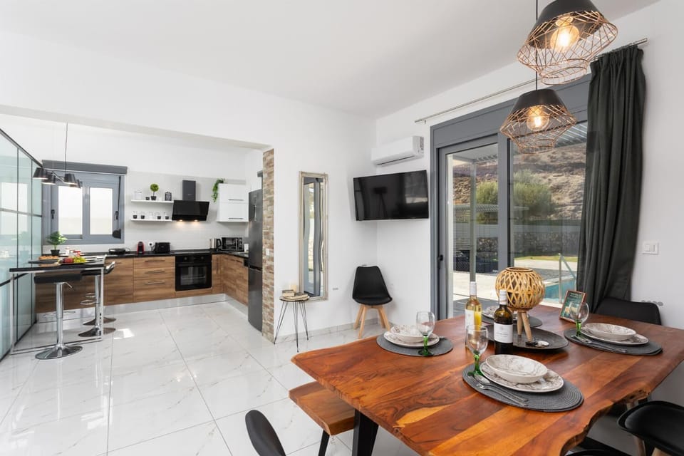 Open-plan living room with sofa, dining area, kitchen, A/C, WiFi internet, and satellite TV