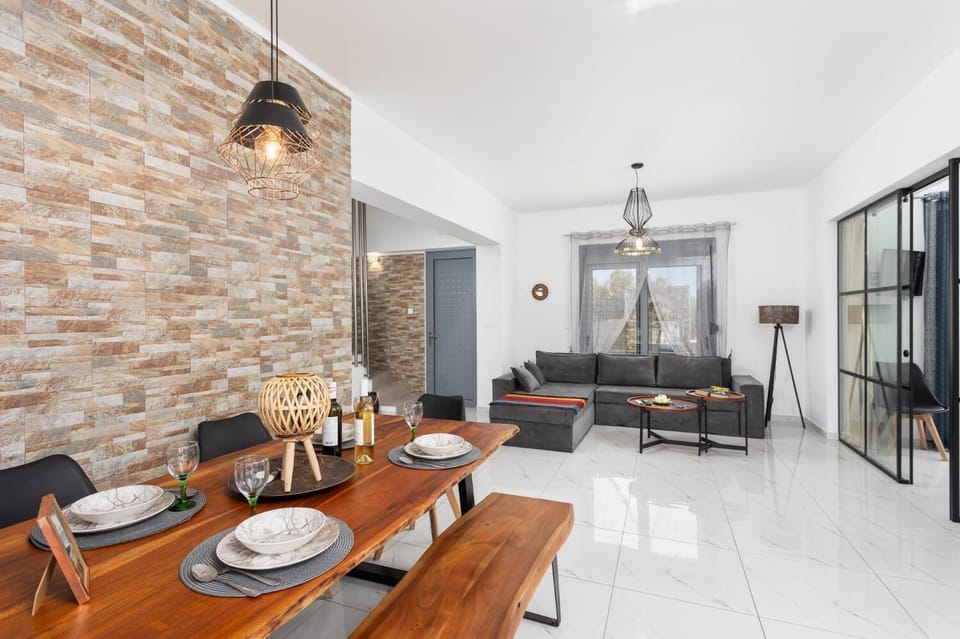 Open-plan living room with sofa, dining area, kitchen, A/C, WiFi internet, and satellite TV