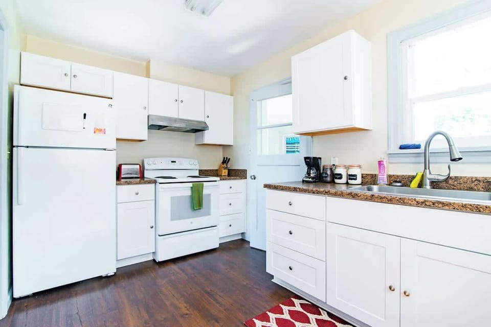The kitchen is stocked with essentials for cooking: pots, pans, salt, pepper, herbs, oil, oven, range, fridge, small coffee pot, and microwave (not pictured). 