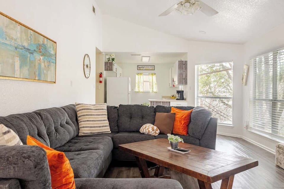 Spacious living room with large sectional, Smart TV, and bright windows, perfect for Spring Break movie nights after floating the Guadalupe River. Gather, relax, and recharge before heading to Gruene Hall or downtown New Braunfels.