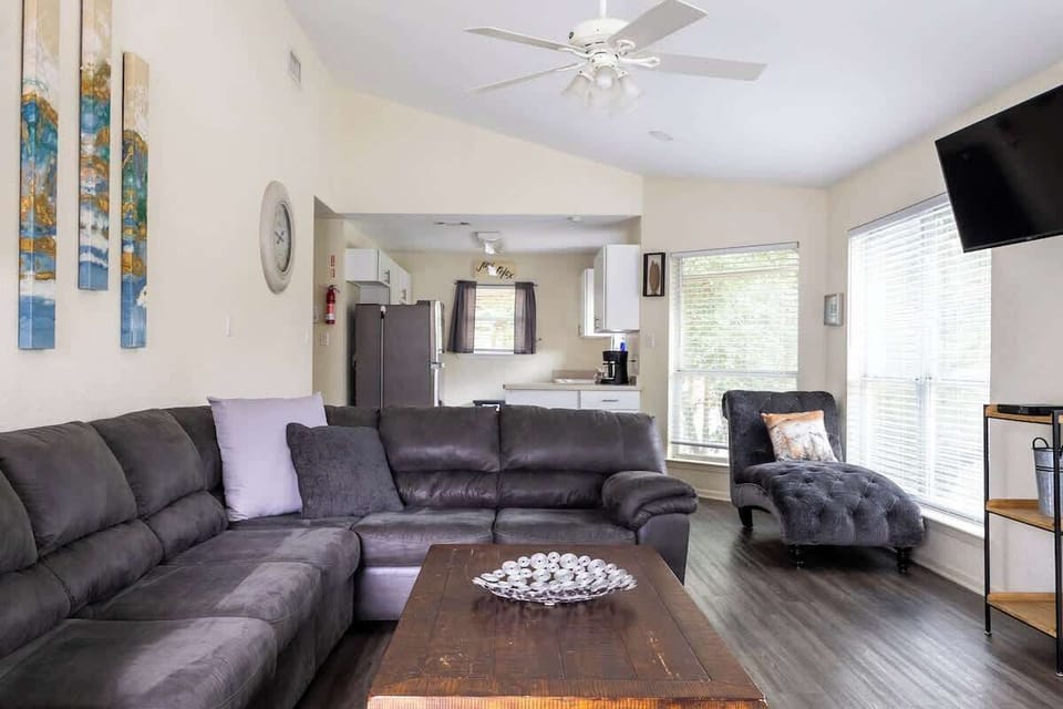 Cozy open-concept layout with sectional seating and plenty of natural light for relaxing or watching movies together.