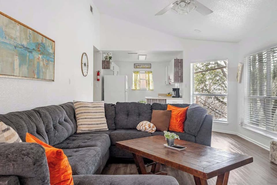 Cozy living room with sectional couch, warm décor, and natural light—ideal for relaxing or gathering with friends and family.