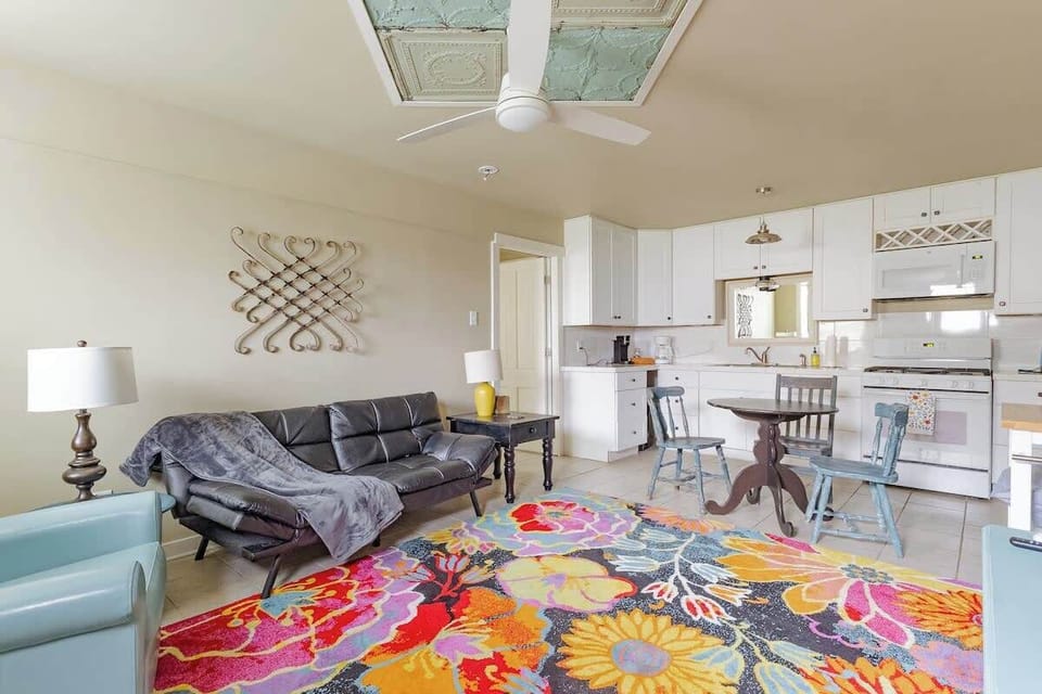 An open and colorful living area with ample seating, ceiling fans, and a relaxed layout that flows seamlessly into the kitchen. Perfect for spending time together while still enjoying personal space, Located at New Braunfels.