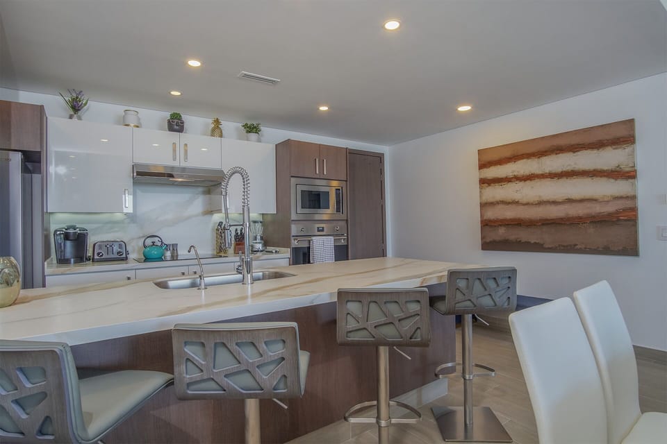4 Contemporary swivel bar stools with low backs at the kitchen counter.